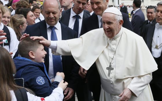 Pope Francis greets a boy during his general audience in St. Peter's Square at the Vatican April 20, 2022. (CNS photo/Paul Haring)