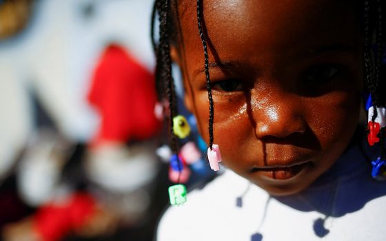 A young Haitian migrant girl traveling with her parents, seeking to reach the U.S., stands outside a temporary shelter at a church in Ciudad Juárez, Mexico, Dec. 20, 2021. (CNS/Reuters/Jose Luis Gonzalez)