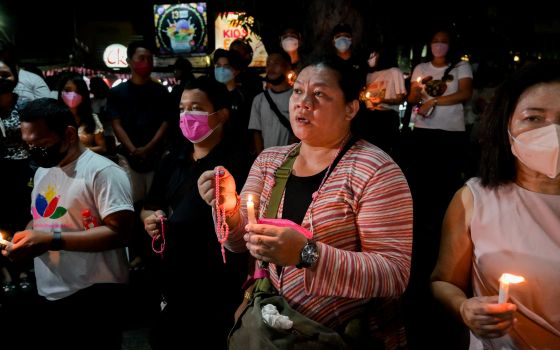 Supporters of Vice President Leonor "Leni" Robredo pray during a candlelight vigil at Plaza Quince Martires in Naga May 9, 2022. (CNS photo/Lisa Marie David, Reuters)