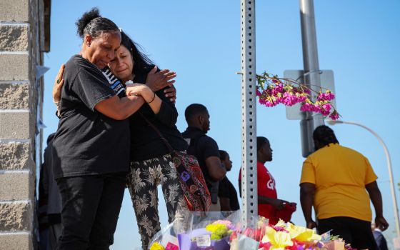 Mourners in Buffalo, N.Y., react May 15, 2022, while attending a vigil for victims of the shooting the day before at a TOPS supermarket. (CNS photo/Brendan McDermid, Reuters)