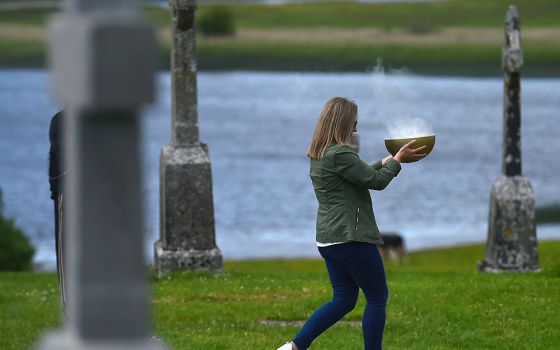 A delegate carries a bowl of incense during a prayer walk at a pre-synodal assembly in the sixth-century monastic site of Clonmacnoise in Ireland June 18. (CNS/Reuters/Clodagh Kilcoyne)