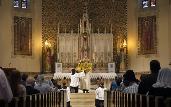 A priest elevates the Eucharist during a traditional Tridentine-rite Mass in July 2021 at St. Josaphat Church in the Queens borough of New York City. (CNS photo/Gregory A. Shemitz)