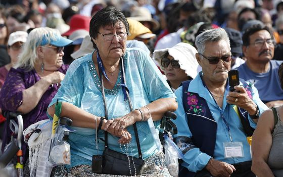 A woman holds a rosary as people wait for the start of Pope Francis' celebration of Mass at Commonwealth Stadium July 26 in Edmonton, Alberta. (CNS/Paul Haring)