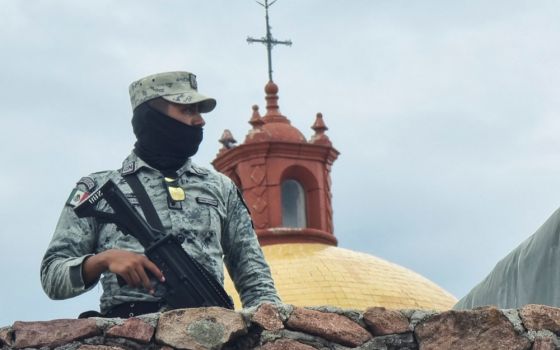 A member of the Mexican army stands guard outside a church in the parish community of Cerocahui June 22. (CNS/Reuters)