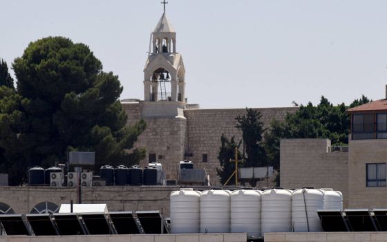 Black and white tanks, each capable of holding 1,500 liters of water, rest on top of a school near the Church of the Nativity in Bethlehem, West Bank, Aug. 22, 2022. Israel has strict control of water sources for Palestinians. (CNS photo/Debbie Hill)