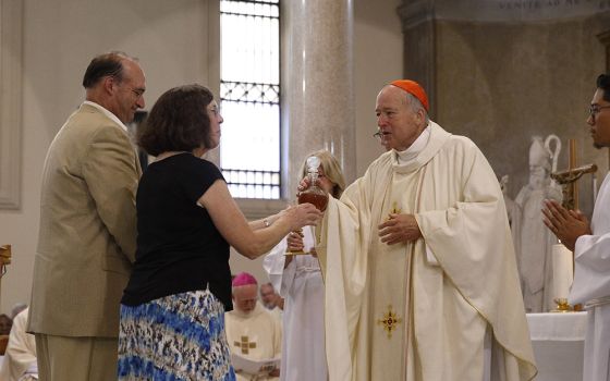 New Cardinal Robert McElroy of San Diego accepts offertory gifts from his sister, Kathy Schreiner, and brother, Walter McElroy, as he celebrates a Mass of thanksgiving at St. Patrick's Church Aug. 28 in Rome. (CNS photo/Paul Haring)