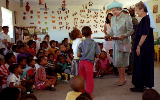 Britain's Queen Elizabeth II visits children at a clinic run by Sr. Ethel Normoyle, in New Brighton, South Africa in 1995