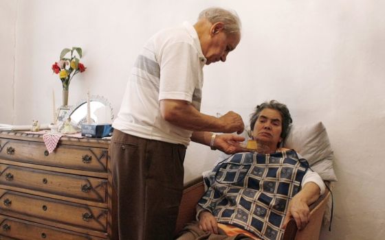 A husband feeds his wife, an Alzheimer's patient, in their house in Lisbon, Portugal, in this 2009, file photo.