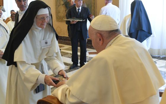 Pope Francis accepts a book from Sister Mary Norbert Loushin during an audience with the Canons Regular of Prémontré, commonly known as the Norbertines, at the Vatican Sept. 22, 2022.