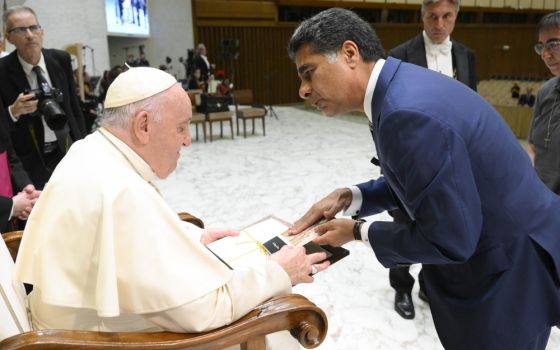 Pope Francis accepts materials from Punit Renjen, CEO of Deloitte Global, during an audience with a delegation from Deloitte Global in the Paul VI hall at the Vatican Sept. 22, 2022. 