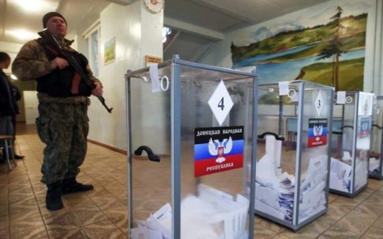 A Russian soldier stands guard at a polling station in Ukraine's Donetsk region Sept. 23, 2022.