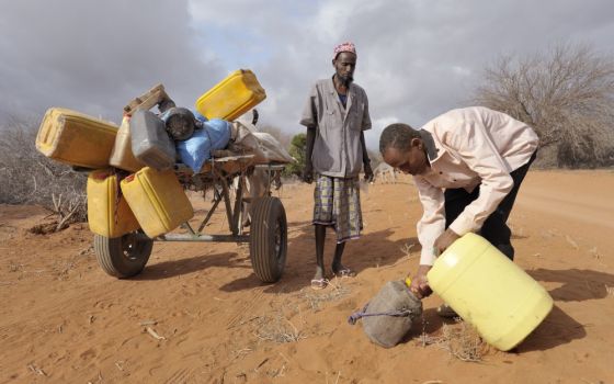 Adow Ibrahim Ali, right, is pictured in a file photo providing water to Ibrahim Osman Mohammed in a remote section of eastern Kenya near the Somali border