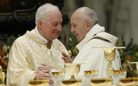 Pope Francis greets Cardinal Marc Ouellet, prefect of the Congregation for Bishops, during the sign of peace as he celebrates Mass marking the feast of the Epiphany in St. Peter's Basilica at the Vatican Jan. 6, 2020. (CNS photo/Paul Haring)