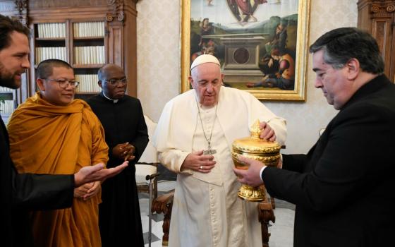 Pope Francis receives a gift from members of a delegation of Buddhists from Cambodia in the library of the Apostolic Palace at the Vatican Jan. 19, 2023. (CNS/Vatican Media)