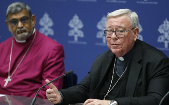 Cardinal Jean-Claude Hollerich of Luxembourg, relator general of the Synod of Bishops, speaks during a news conference at the Vatican Jan. 23, 2023. Also pictured is Anglican Archbishop Ian Ernest, the archbishop of Canterbury's representative in Rome. Speakers discussed an upcoming ecumenical prayer vigil to be held Sept. 30, 2023, before the meeting of the Synod of Bishops. (CNS photo/Paul Haring)