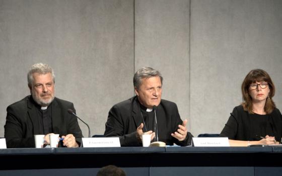 Cardinal Mario Grech, center, secretary-general of the Synod of Bishops, speaks at a news conference at the Vatican Oct. 27, 2022, to present the document for the continental phase of the Synod on Synodality. Also pictured are Italian Jesuit Father Giacomo Costa, adviser to the secretary-general of the synod, and Anna Rowlands, professor of Catholic social thought and practice at Durham University in the United Kingdom. (CNS/Junno Arocho Esteves)