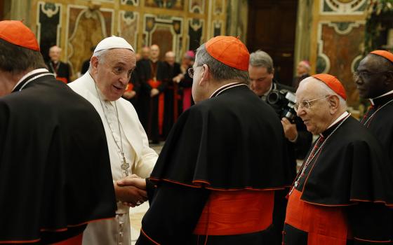 Pope Francis greets U.S. Cardinal Raymond Burke, patron of the Knights and Dames of Malta, during an audience to exchange Christmas greetings with members of the Roman Curia in Clementine Hall at the Vatican Dec. 22, 2014. (CNS/Paul Haring)