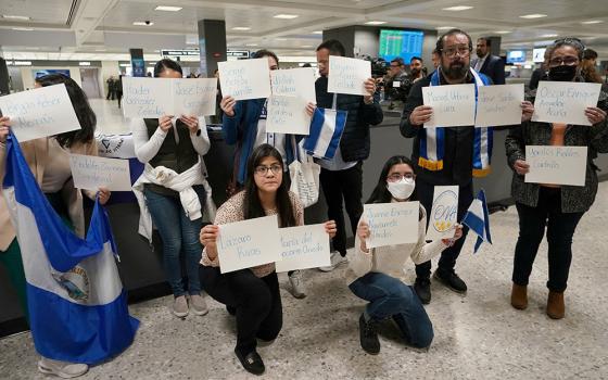 Activists hold up signs with the names of some of the more than 200 political prisoners released from Nicaragua, as they await their arrival at Dulles International Airport Feb. 9 in Virginia. (OSV News/Reuters/Kevin Lamarque)