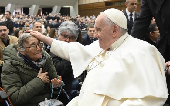 Pope Francis blesses a woman after his weekly general audience Feb. 15 in the Vatican audience hall. (CNS/Vatican Media)