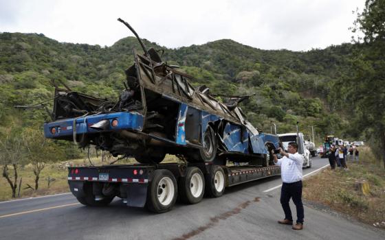 A trailer transports the wreckage of a bus, which was carrying migrants who had traveled through the Darien Gap, in Los Planes de Gualaca, Panama, Feb. 15. (OSV News/Reuters)