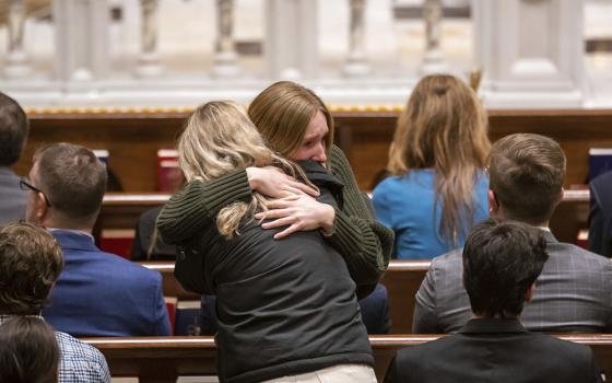 Friends and supporters console each other during a memorial service for Brian Fraser at St. Paul on the Lake Catholic Church in Grosse Pointe Farms, Michigan, Feb. 14. Fraser was identified as one of the students slain during a mass shooting on Michigan State University's campus the night before. (Detroit News via AP, Pool/David Guralnick)