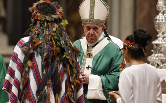 Pope Francis accepts offertory gifts from Indigenous people at the concluding Mass of the Synod of Bishops for the Amazon at the Vatican in this Oct. 27, 2019, file photo. The Vatican on Feb. 12, 2020, released the pope's apostolic exhortation, Querida Amazonia ("Beloved Amazonia"), which offers his conclusions from the synod. (CNS/Paul Haring)