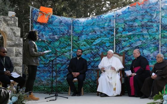Pope Francis meets with migrants at the John XXIII Peace Lab's Center for Migrants in Hal Far, Malta, April 3, 2022. The backdrop was built with plastic bottles and life vests pulled from the sea. (CNS photo/Paul Haring)