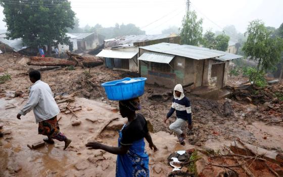 People walk past houses in Blantyre, Malawi, March 17, 2023, which were damaged in the aftermath of Cyclone Freddy. (OSV News/Reuters/Esa Alexander)