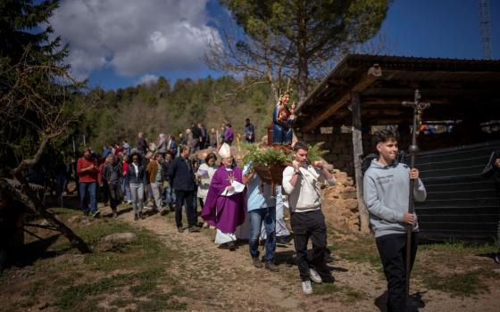 Local residents take part in a procession carrying a replica of the Our Lady of the Torrents, a virgin historically associated with drought, in l'Espunyola, north of Barcelona, Spain, Sunday, March 26, 2023. (AP Photo/Emilio Morenatti)