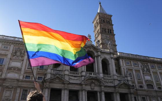 A demonstrator waves a rainbow flag in front of the Basilica of St. Mary Major during the annual Pride march in Rome June 26, 2021. (AP/Gregorio Borgia)