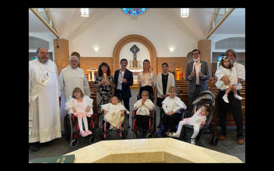 The Greenan family is pictured on the day of the baptism of their adopted children from Ukraine, at St. John Vianney in Prince Frederick, Maryland. Pictured in the front row, left to right, are: Dasha, Tatyana, Sawyer, Anthony and Cabrini. In the back row, left to right, are Deacon Jim Caldwell; Fr. Peter Daly; Vicki, Michael, Carolyn and Alex Greenan; Brandon Szalinski (Carolyn's fiance); and Ed Greenan, holding Anya. (Courtesy of the Greenan family)