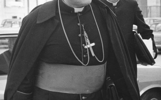 Black and white photo of Cardinal Karol Wojtyla (who later became Pope John Paul II) with a priest in the background