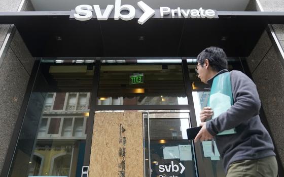 A pedestrian passes a Silicon Valley Bank branch March 13 in San Francisco. (AP photo/Jeff Chiu)