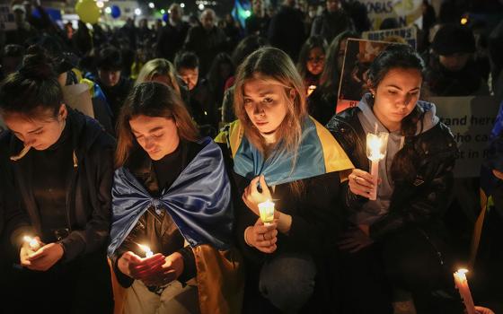 People carrying Ukrainian national flags and anti-war signs participate in a torchlight procession in the district where the Russian Embassy is in Rome Feb. 24, 2023, on the first anniversary of the Russian invasion of Ukraine. (AP/Alessandra Tarantino)