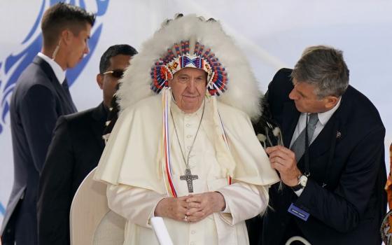 Pope Francis dons a headdress that was gifted to him during a visit with Indigenous peoples at Maskwaci, the former Ermineskin Residential School, Monday, July 25, 2022, in Maskwacis, Alberta. (AP Photo/Eric Gay)