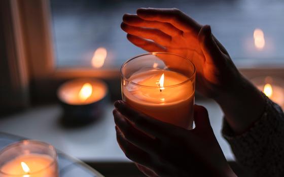 Hands holding a candle (Unsplash/Rebecca Peterson Hall)