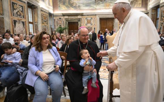Pope Francis greets a child and Archbishop Francisco Cerro Chaves of Toeldo, Spain, during an audience with the archdiocese's Mother of Hope of Talavera de la Reina Foundation at the Vatican April 15, 2023. (CNS photo/Vatican Media)