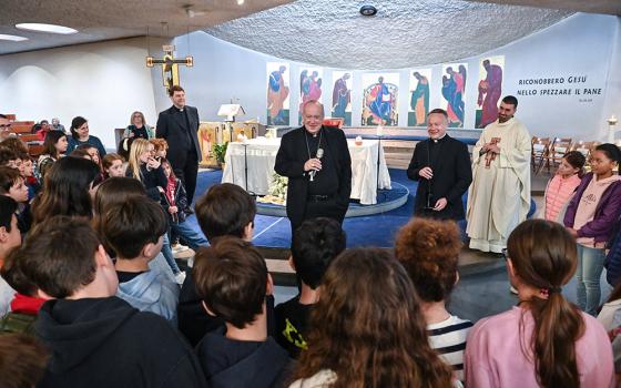 Cardinal Robert W. McElroy of San Diego speaks with young members of the parish of St. Frumentius, his titular church in Rome, before formally taking possession of the church and celebrating Mass there April 23. (CNS/Chris Warde-Jones)