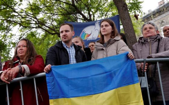 Ukrainians hold the Ukrainian flag at the Church of Saint Elizabeth of Hungary as Pope Francis meets with the poor and with refugees during his apostolic journey in Budapest, Hungary, April 29, 2023. 