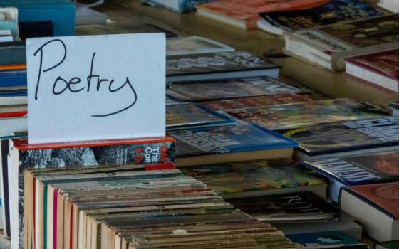Handwritten sign labeled "Poetry" marks a spot in a bin of books.