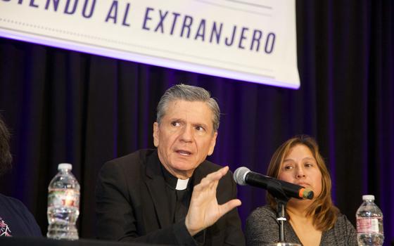 Archbishop Gustavo García-Siller of San Antonio speaks during a recent convocation to celebrate "Recognizing the Stranger," a parish-centered initiative funded by the U.S. bishops' Catholic Campaign for Human Development and implemented by the West/Southwest Industrial Areas Foundation, a network of community- and faith-based organizations. Seated beside the archbishop is Maricela Pineda, who participated in the program. (Courtesy of Alan Pogue)