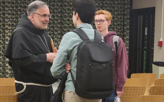 Bishop John Stowe of Lexington, Kentucky talks with students from Loyola University Chicago after the bishop's talk on "Synodality and the Common Good" April 11. (NCR photo/Heidi Schlumpf)