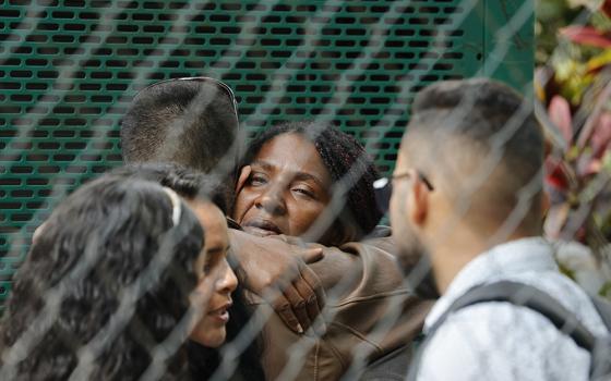 Angie Milagros Infante, mother of Rannier Requena Infante, who died at a migrant facility fire March 27 in Ciudad Juárez, Mexico, embraces relatives after recognizing the body of her son at a morgue in Caracas, Venezuela, April 17. (AP/Jesus Vargas)