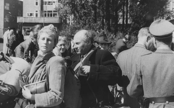 Amsterdam Jews await deportation to the Nazi transit camp in Westerbork, the Netherlands, on June 20, 1943. A member of the German Security Police can be seen at right. (Wikimedia Commons/Netwerk Oorlogsbronnen/Herman Heukels)