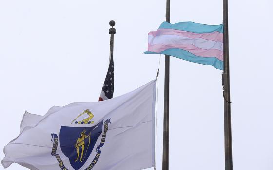 A flag representing the transgender community, foreground, flies next to the Massachusetts state flag and a U.S. flag in front of Boston City Hall in 2016. (AP/Steven Senne)