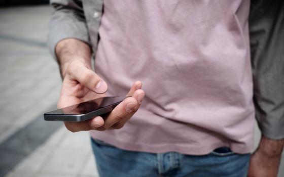 A person looks at a smartphone. (Unsplash/Clique Images)