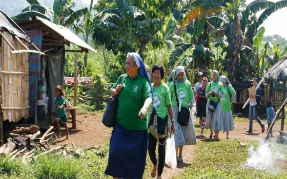 Sisters from different congregations who are part of the Rural Missionaries of the Philippines make home visits with villagers. (Courtesy of Rural Missionaries of the Philippines)