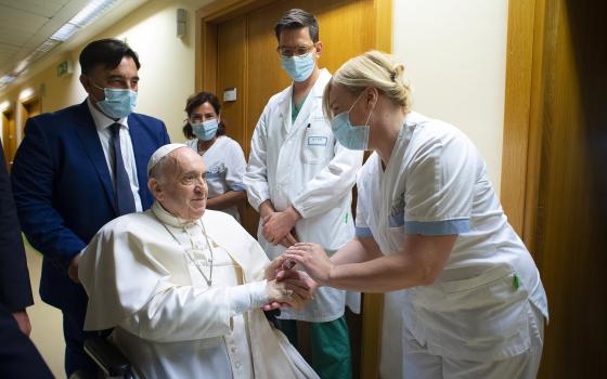 Pope Francis gives a rosary to a member of the medical staff at Gemelli hospital in Rome July 11, 2021, as he recovers following scheduled colon surgery. The pope was in the hospital for 10 days. (CNS photo/Vatican Media via Reuters)