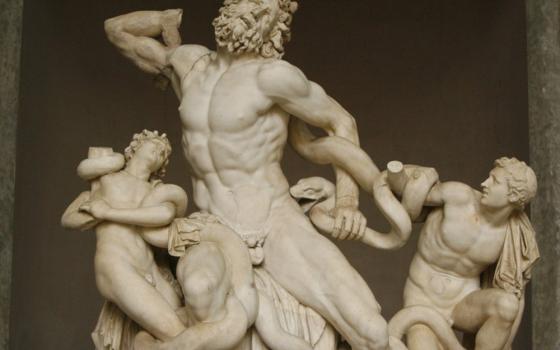A marble statue depicts a naked man and two smaller men wrapped in snakes
