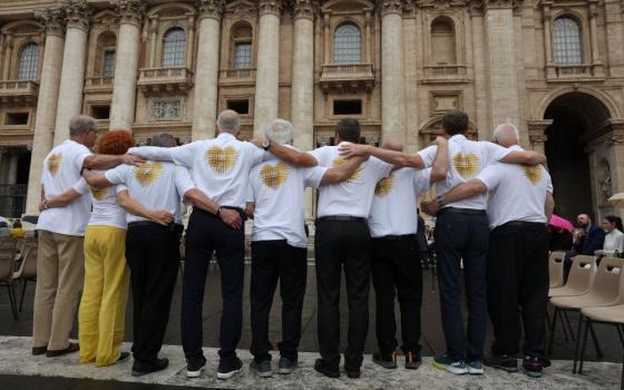 Eight men and one woman stand facing St. Peter's Basilica at the end of Pope Francis' weekly general audience in St. Peter's Square at the Vatican May 17. 